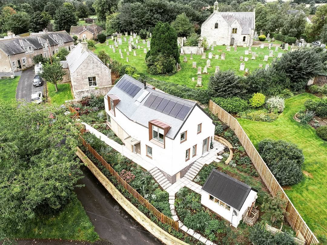 Renovated white cottage beside a village churchyard