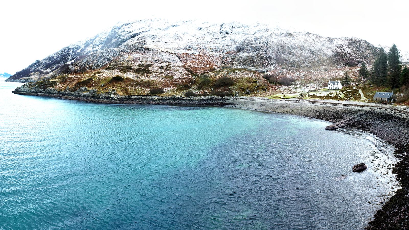 Turquoise bay and snow-dusted hills at Mallaig Mhor from the air