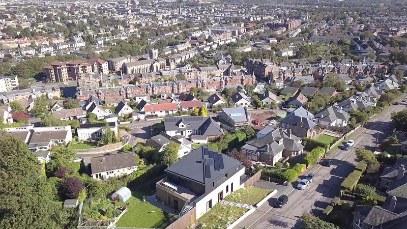 Aerial view over south Edinburgh rooftops towards the city centre, with the new house in the foreground